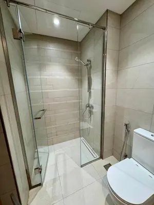 a bathroom with a glass shower and a toilet at Dubai - Brand New Apartment in Dubai
