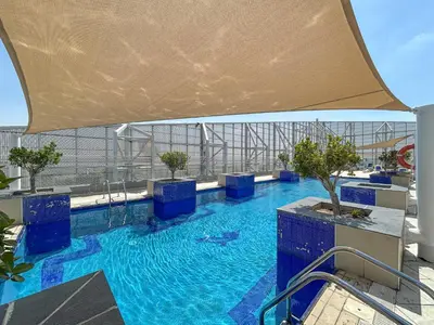 a large swimming pool with blue water on a building at Premium & Cozy Home in the Heart of Sports City in Dubai