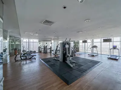 a gym with treadmills and exercise equipment in a building at Premium & Cozy Home in the Heart of Sports City in Dubai