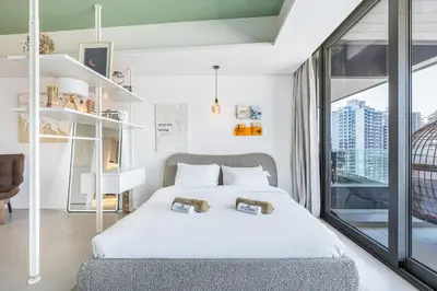 a bedroom with a white bed and a large window at Premium & Cozy Home in the Heart of Sports City in Dubai