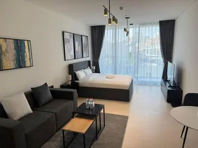 a living room with a bed and a couch and a tv at Disalvo Smart and Luxury Studio in Dubai