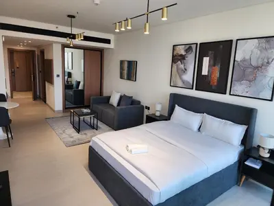 a bedroom with a bed and a living room at Disalvo Smart and Luxury Studio in Dubai