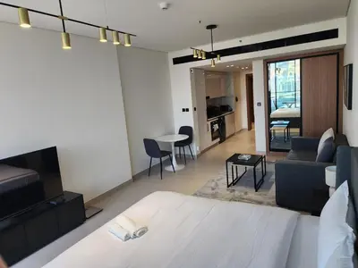 a bedroom with a bed and a living room at Disalvo Smart and Luxury Studio in Dubai