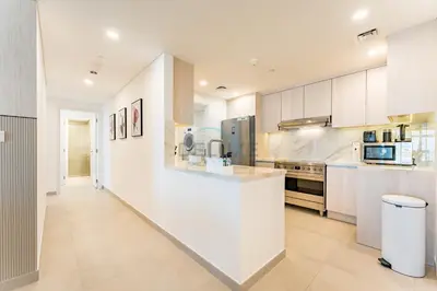 a large kitchen with white cabinets and a counter at 2BR with Balcony, Exclusive Amenities and Steps from Iconic Landmarks, Madinat Jumeirah Living Rahaal 2, Jumeirah in Dubai