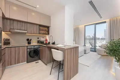 a kitchen and living room with a washer and dryer at StayShort - Sleek Studio in The Ivy Tower, JVT in Dubai