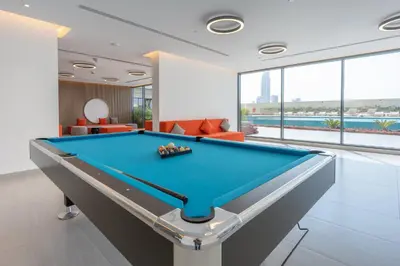 a pool table in a living room with a pool table at StayShort - Sleek Studio in The Ivy Tower, JVT in Dubai
