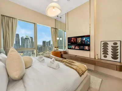 a bedroom with a large white bed with a large window at Crown Jewel 2 Bedroom Apartments I Iconic Burj Khalifa and Fountain Views I Free Parking, Gym, Pool, Wi-Fi and PS5 I by Skyline Serenity in Dubai