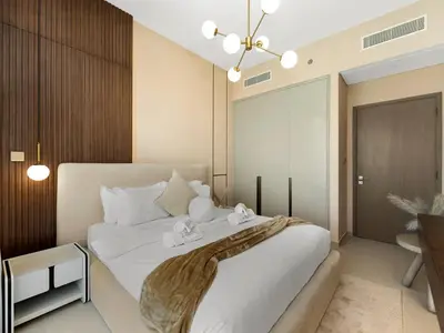 a bedroom with a large white bed and a desk at Crown Jewel 2 Bedroom Apartments I Iconic Burj Khalifa and Fountain Views I Free Parking, Gym, Pool, Wi-Fi and PS5 I by Skyline Serenity in Dubai