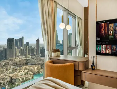 a bedroom with a desk and a view of a city at Crown Jewel 2 Bedroom Apartments I Iconic Burj Khalifa and Fountain Views I Free Parking, Gym, Pool, Wi-Fi and PS5 I by Skyline Serenity in Dubai