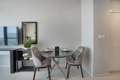 a dining room with a table and chairs and a mirror at EasyGo- Sleek Studio at Damac Hills Artesia D in Dubai