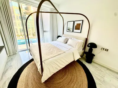 a bedroom with a canopy bed with a large window at The Pad by Omniyat in Dubai