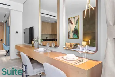 a dining room with a table and chairs at Vibrant & Exclusive Pool View Studio in Autograph in Dubai