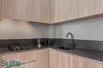 a kitchen with a sink and a counter top at Vibrant & Exclusive Pool View Studio in Autograph in Dubai