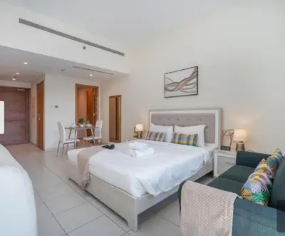 a bedroom with a large bed and a table and chairs at Business Bay Mahek Holiday Home in Dubai