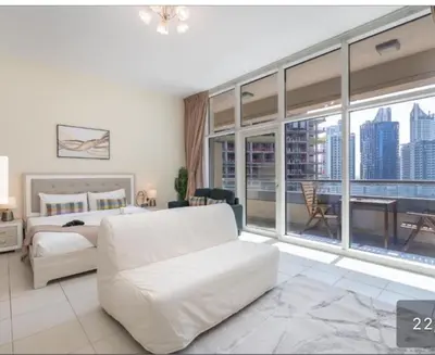a bedroom with a white bed and a large window at Business Bay Mahek Holiday Home in Dubai