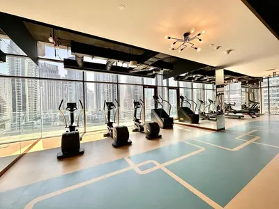 a gym with treadmills and ellipticals in a building at Modern 2BR Skyline & Marina View in Dubai