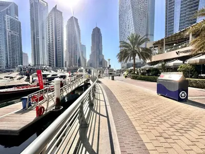a walkway in a city with tall buildings at Modern 2BR Skyline & Marina View in Dubai