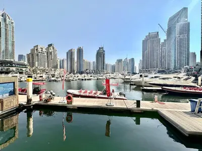 a marina with boats in a city with tall buildings at Modern 2BR Skyline & Marina View in Dubai