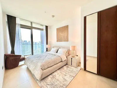 a bedroom with a bed and a large window at Modern 2BR Skyline & Marina View in Dubai