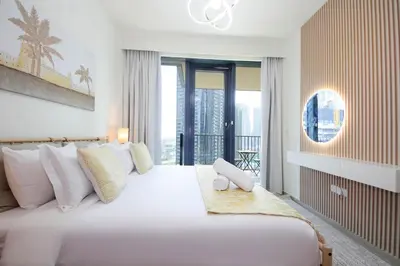a bedroom with a large white bed with a balcony at Spacious 2BHK Boulevard Heights Downtown in Dubai