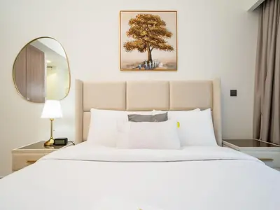 a bedroom with a large white bed and a mirror at Sleek Studio in Azizi Riviera Modern and Cozy Stay in Dubai