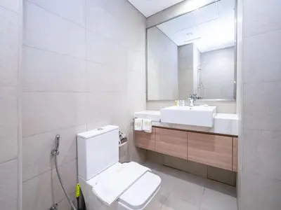 a bathroom with a toilet and a sink and a mirror at Sleek Studio in Azizi Riviera Modern and Cozy Stay in Dubai