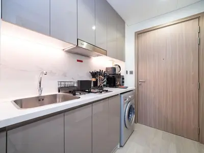 a kitchen with a sink and a washing machine at Sleek Studio in Azizi Riviera Modern and Cozy Stay in Dubai