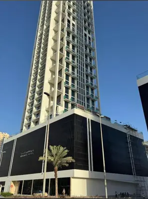 a tall building with a palm tree in front of it at PurityStaysDXB in Dubai