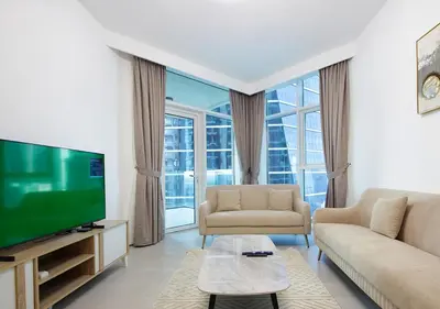 a living room with a flat screen tv and a couch at Luxury 2BR Apartment in Urban Oasis by Missoni in Dubai
