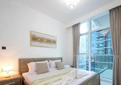a bedroom with a bed and a large window at Luxury 2BR Apartment in Urban Oasis by Missoni in Dubai
