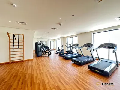 a gym with several treadmills and elliptical machines at Elegant 1-Bedroom Apartment in Dubai Silicon Oasis - by Alphatel Vacations in Dubai