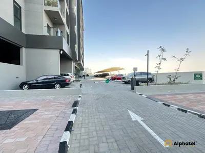 a parking lot with cars parked next to a building at Elegant 1-Bedroom Apartment in Dubai Silicon Oasis - by Alphatel Vacations in Dubai