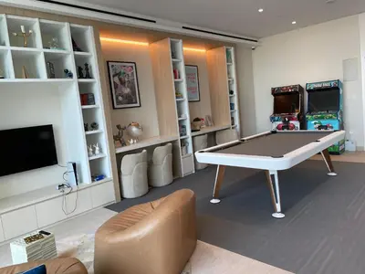 a living room with a ping pong table and a tv at Luxurious 1BDR apartment in MBR City in Dubai