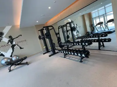 a gym with several rows of exercise equipment in a room at Luxurious 1BDR apartment in MBR City in Dubai