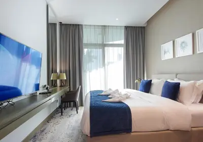 a hotel room with a large bed and a television at Breathtaking Views Studio Apartment in Damac Prive in Dubai