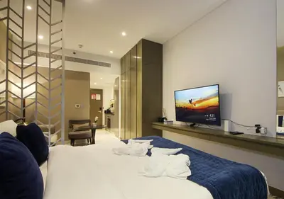 a bedroom with a large bed with a tv on the wall at Breathtaking Views Studio Apartment in Damac Prive in Dubai