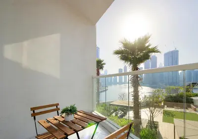 a balcony with a wooden bench and a palm tree at Breathtaking Views Studio Apartment in Damac Prive in Dubai