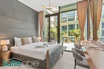 a bedroom with a large bed and a table and chairs at Aesthetic Studio with Stunning Pool View in JVC in Dubai