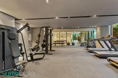 a gym with treadmills and machines in a room at Aesthetic Studio with Stunning Pool View in JVC in Dubai