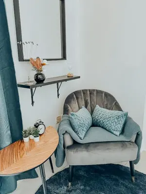 a couch with pillows on it next to a table at LivWithUs - 2 BR in Marina View Tower B in Dubai