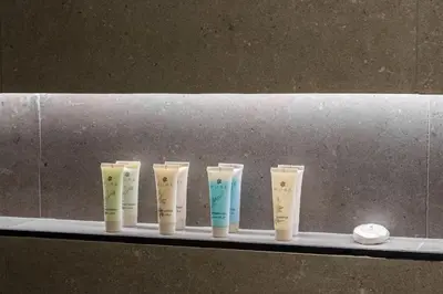 a row of four differently colored vases on a shelf at Modern Studio Apartment JVC in Dubai