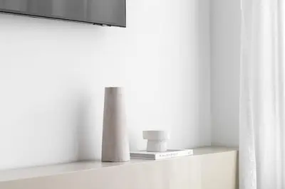 a shelf with two vases and a television on it at Modern Studio Apartment JVC in Dubai