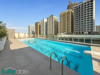 a swimming pool on the roof of a building with tall buildings at Sophisticated 1 Bedroom in Binghatti Galaxy JVC in Dubai