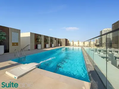 a large swimming pool with blue water in a building at Sophisticated 1 Bedroom in Binghatti Galaxy JVC in Dubai