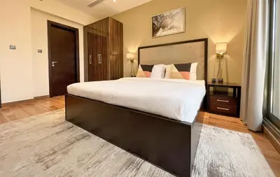a large bedroom with a large bed with white sheets at 1BDR with Burj Khalifa Views in Elite Downtown in Dubai