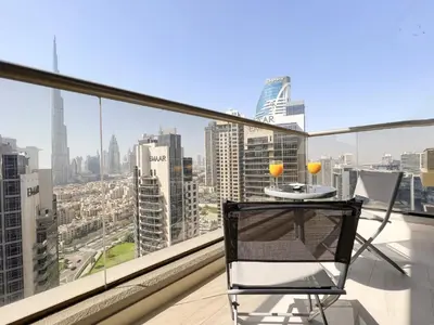 a chair on a balcony with a view of a city at 1BDR with Burj Khalifa Views in Elite Downtown in Dubai