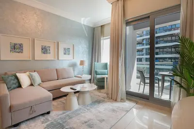 a living room with a couch and a large window at EasyGo - Chic 1BR in Damac Maison in Dubai