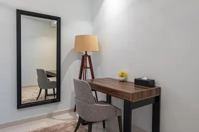 a room with a table and chairs and a mirror at 3 Bedroom - Pool Access - 7 mins to Dubai Mall - Sun Set View in Dubai