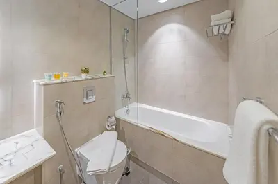 a bathroom with a tub and a toilet and a sink at 3 Bedroom - Pool Access - 7 mins to Dubai Mall - Sun Set View in Dubai