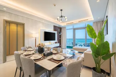 a dining room with a table and a living room at 3 Bedroom - Pool Access - 7 mins to Dubai Mall - Sun Set View in Dubai